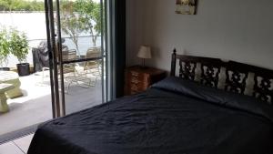 a bedroom with a bed and a balcony with a table at Bimini Motel in Hollywood