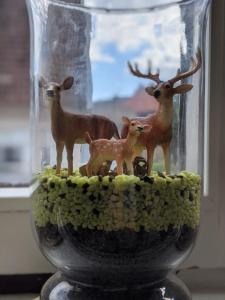 a glass vase with figurines of animals in it at Zur ForsHütte in Braunlage