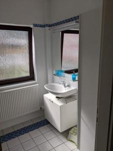 a white bathroom with a sink and a mirror at Zur ForsHütte in Braunlage