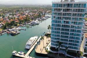 a large building next to a river with boats in it at Nautico departamento Marina Vallarta in Puerto Vallarta