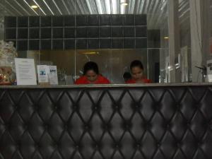 a couple of women standing behind a counter at BnT Inn in Mactan