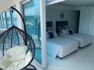 a room with two beds and a chair on a balcony at Nautico departamento Marina Vallarta in Puerto Vallarta +19 photos