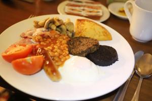 een bord met vlees en groenten op tafel bij Ben Wyvis Hotel in Strathpeffer