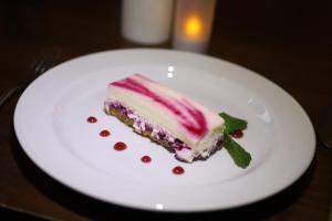 un trozo de pastel en un plato blanco en una mesa en Ben Wyvis Hotel en Strathpeffer