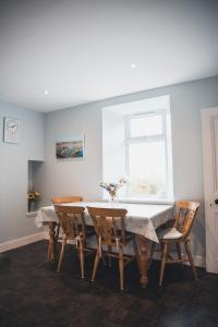 a dining room table with chairs and a window at West Gallaton Farmhouse in Stonehaven