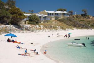 a group of people on a beach with a boat at Stay Rottnest in Rottnest Island +26 photos