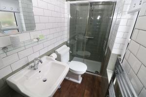 a bathroom with a toilet and a sink and a shower at Four Seasons Guesthouse in Castleton