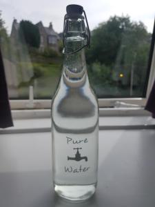 a bottle of water sitting on a window sill at Rose Villa in Oban