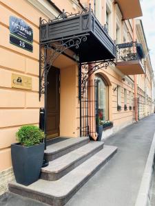 wejście do budynku ze schodami i balkonem w obiekcie Statskij Sovetnik Hotel Kustarnyy w Petersburgu