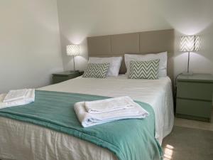 a bedroom with a large bed with towels on it at Casa do Mar in Peniche