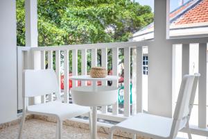 a white porch with two chairs and a table at Boutique Homes Willemstad City Centre in Willemstad