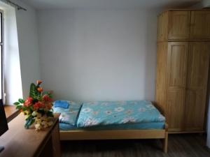 Apartment Pavel في Velké Poříčí: غرفة نوم صغيرة مع سرير وخزانة خشبية