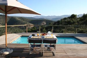 a table with chairs and an umbrella next to a pool at Sederkloof Lodge in Studtis