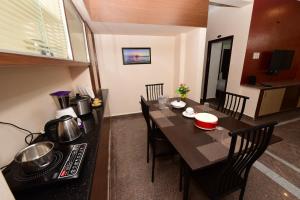 - une cuisine et une salle à manger avec une table et une cuisinière dans l'établissement Sree Service apartments, à Tirupati