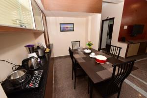 a kitchen and dining room with a table and a stove at Sree Service apartments in Tirupati