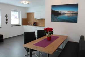 a kitchen with a wooden table with a vase of flowers on it at Apart Alpinlive in Ladis