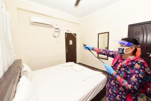une femme dans une pièce avec un lit et un masque dans l'établissement Sree Service apartments, à Tirupati