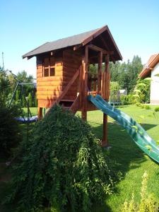 a playground with a slide and a house at Pokoje z aneksami kuchennymi u Wiktorii in Sromowce Niżne