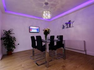 a dining room with a table and black chairs at Sycamore House in Leeds