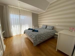 a bedroom with a bed and a large window at Top villa with extraordinary view of Atlantic in São Martinho do Porto +43 photos