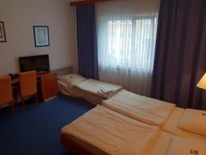 Postel nebo postele na pokoji v ubytování City Hotel Stuttgart