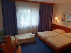 Postel nebo postele na pokoji v ubytování City Hotel Stuttgart