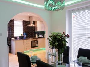 a dining room with a table with a vase of flowers at Sycamore House in Leeds