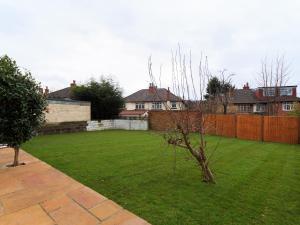 a yard with houses and a fence and a tree at Sycamore House in Leeds