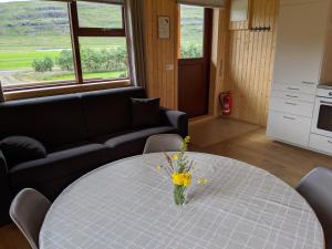 una sala de estar con una mesa con un jarrón de flores. en Stóra-Vatnshorn en Búðardalur