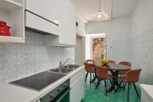 a kitchen with a sink and a table with chairs at Villa Magnolia in Cavtat