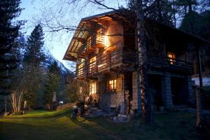 una gran casa de madera con luces encendidas en The Guest House, en Vallorcine