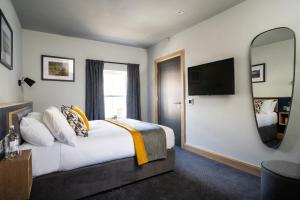 um quarto de hotel com uma cama grande e um espelho em Hillyard House Hotel em Castlewellan