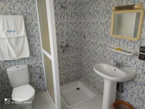 a bathroom with a sink and a toilet and a mirror at H&ocirc;tel Petite Su&egrave;de in Agadir
