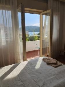 a bedroom with a bed and a large window at Guesthouse Mila in Tisno