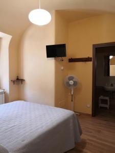 um quarto com uma cama e uma televisão de ecrã plano em Alla Piazza Vecchia em Scanno