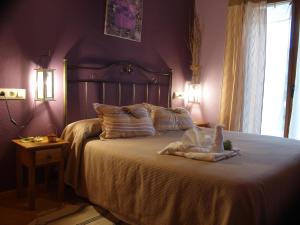 1 dormitorio con 1 cama con pared morada en Alojamientos rurales Angelita, en Olocau del Rey