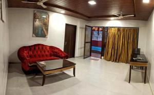 a living room with a red couch and a table at Villa 406, Dr Wade with Private Pool and Gazebo in Royal Palms Mumbai in Mumbai