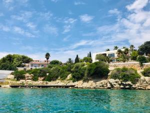 a view of a villa from the water at Splendide Villa les pieds dans l'eau dans la baie de Mahon in Es Castell