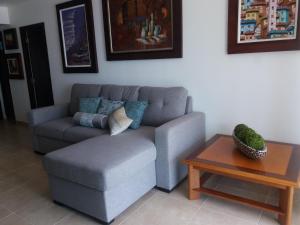 sala de estar con sofá y mesa en Acogedor departamento con playa privada, en Salinas