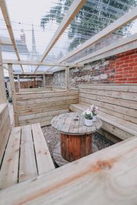 un patio de madera con mesa de madera y bancos en The Town Arms, en Wallingford