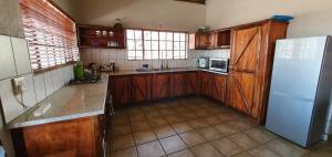 a kitchen with wooden cabinets and a white refrigerator at Leap in2 Africa in Marloth Park