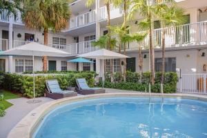 a swimming pool in front of a building with palm trees at Coral Reef at Key Biscayne in Miami