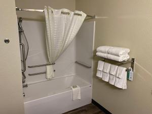 een badkamer met een bad en handdoeken bij Cobblestone Inn & Suites - Forest City in Forest City