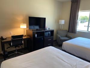 um quarto de hotel com duas camas e uma televisão de ecrã plano em Cobblestone Inn & Suites - Forest City em Forest City