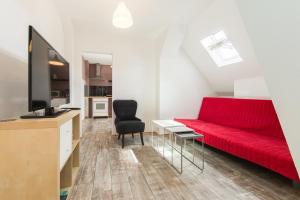 - un salon avec un canapé rouge et une chaise dans l'établissement primeflats - Apartments Panke Berlin-Wedding, à Berlin