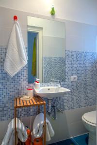 ローマにあるユリシーズ イン ロームの青いタイル張りのバスルーム(洗面台、トイレ付)