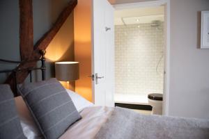 un dormitorio con una cama y un baño en The Talkhouse, en Stanton Saint John