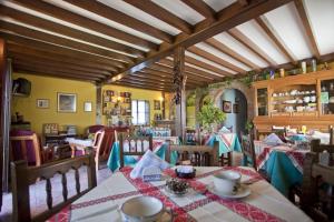 a dining room with tables and chairs in a room at Posada los Taranos in Valdaliga 