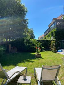 een paar stoelen en een tafel in een tuin bij Maison Jenny Hotel Restaurant & Spa in Hagenthal-le-Bas