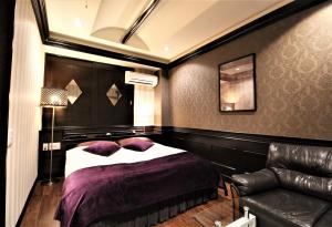 una camera con letto e divano in pelle di Hotel Riviera Sagamihara (Adult Only) a Sagamihara